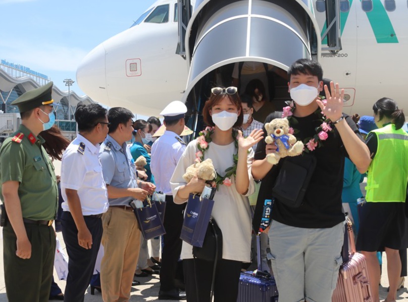 Các du khách được lãnh đạo tặng hoa và quà khi xuống sân bay
